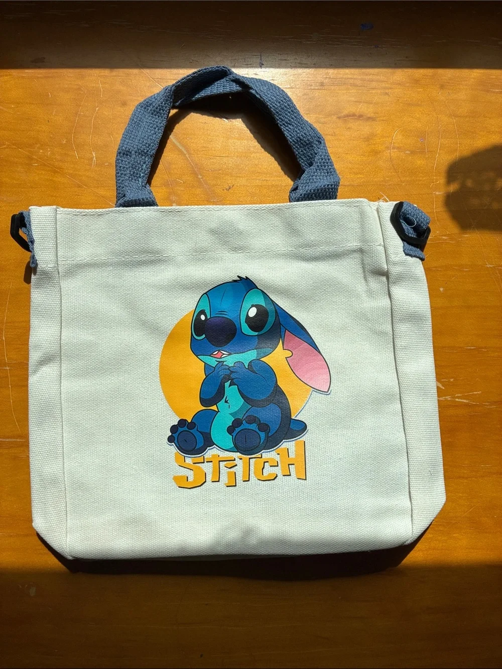 Stitch Canvas Tote in Cream with Blue Stitch Graphic. It’s a Crossbody bag too